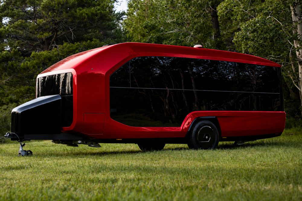 Candy apple red Pebble Flow concept parked on grass in front of aspens and pines